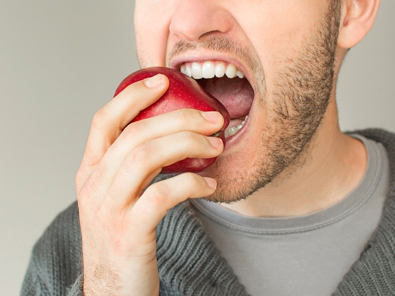 mężczyzna jedzący jabłko